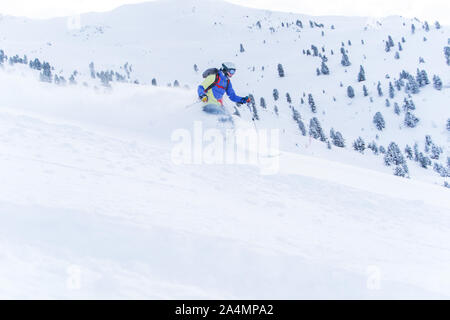 Foto von Athlet Mann in der Maske und Helm im Winter Ski Resort auf dem Hintergrund der Hügel mit Bäumen Stockfoto