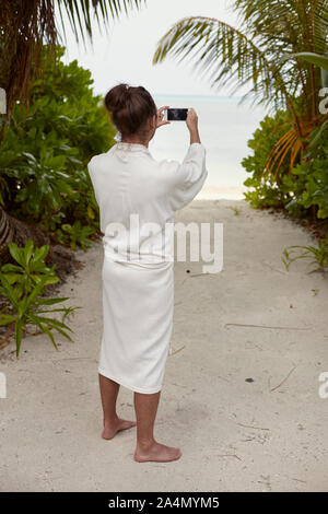 Mann, der morgenmantel am Strand Stockfoto