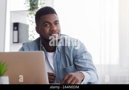 Portrait der junge Geschäftsmann an seinem Arbeitsplatz im Büro zu sitzen Stockfoto