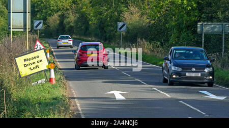 Anzahl Platten PIXELLATED DURCH PA BILD SCHREIBTISCH. Bitte fahren Sie auf der linken Seite Schilder und Pfeile auf die B4031 Straße RAF Croughton, in Northamptonshire, wo Harry Dunn, 19, starb, als sein Motorrad in einem Kopf beteiligt war gelegt - auf Kollision im August. Stockfoto