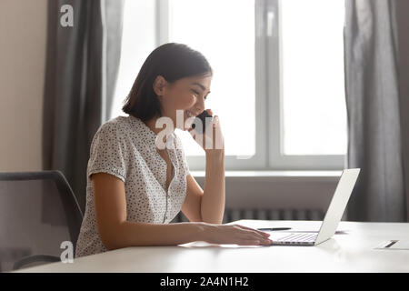Lächelnd asiatischen Geschäftsfrau am Telefon sprechen und mit Laptop Stockfoto