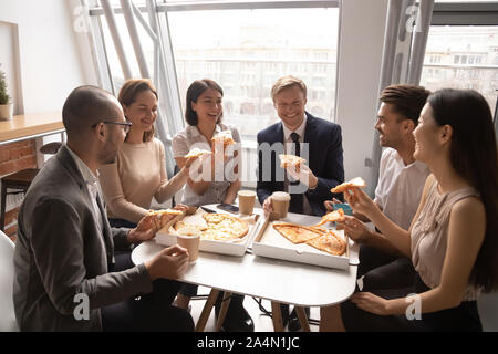 Gerne diverse Mitarbeiter Spaß, Pizza zu genießen Stockfoto