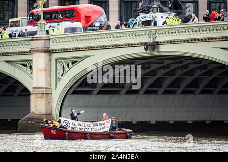London, Großbritannien. 15 Okt, 2019. Aussterben Rebellion Demonstranten auf einem Boot in der Nähe der Westminster Bridge mit einem Boris Johnson Imitator in London, UK. Quelle: Wladimir Morosow/akxmedia. Quelle: Wladimir Morosow/Alamy leben Nachrichten Stockfoto