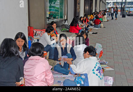 Eingewanderte Arbeiter Frauen spielen Karte in Straße, Hong Kong Island, China Stockfoto