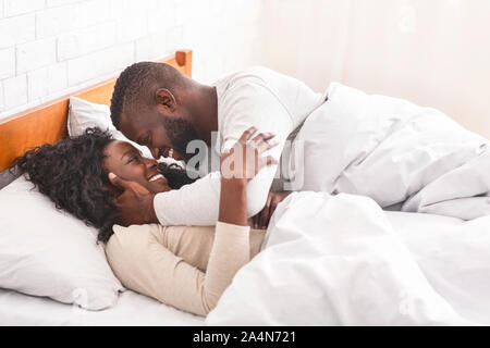Afrikanische amerikanische Paar ausgaben Morgen im Bett, Kuscheln und küssen Stockfoto