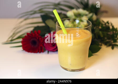 Gesunde und leckere selbstgemachte Smoothie (s) mit einer Blume auf dem Tisch. Closeup still life Bild. Gesunde, leckere und nahrhafte Zwischenmahlzeit, lecker! Stockfoto