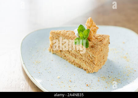 Honig Kuchen mit Baiser und Minze dekoriert. Frühstück im Café, Kaffee am Morgen. am Holztisch. Restaurant Menü Stockfoto