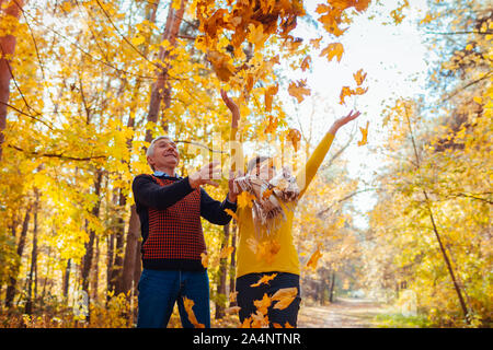Herbst Jahreszeit. Paar Blätter im Herbst Wald werfen. Senior Familie Spaß im Freien Stockfoto