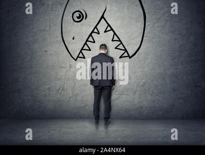 Geschäftsmann mit seinem Kopf zwischen die Zähne der großen Hand gezeichneten Monster bereit, ihn zu essen Stockfoto
