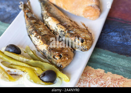 Mit leckeren gegrillten Sardinen, garniert mit Paprika, Oliven und Zwiebeln Platte Stockfoto