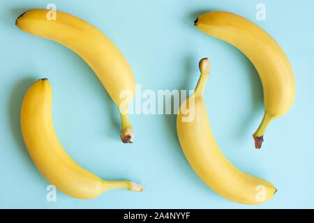 Blick von oben auf die reife Bananen auf pastellfarbenen Hintergrund. Kreative Komposition mit Bananen. Stockfoto