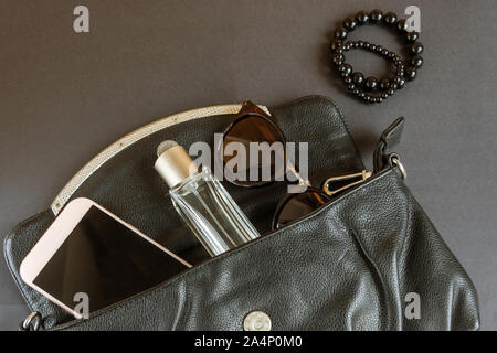 Zusammensetzung mit Frauen Inhalt in der Moderne Tasche flach. Chaos in der Frau kleine Handtasche Stockfoto