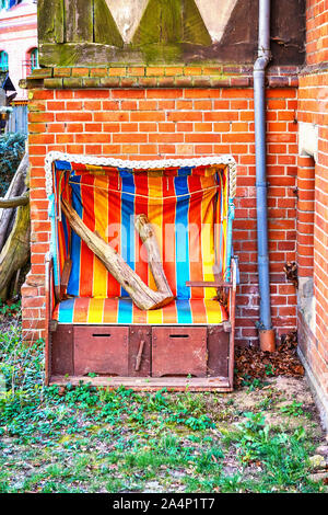 Bunter Strandkorb im Garten in einem alten Haus. Stockfoto