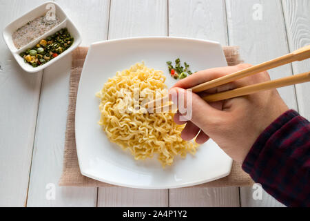 Mann essen Nudeln mit Stäbchen Stockfoto