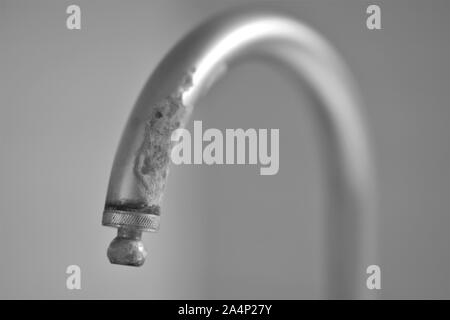 Alte Wasserhahn in Kalk, selektiver Fokus, Bw Stockfoto