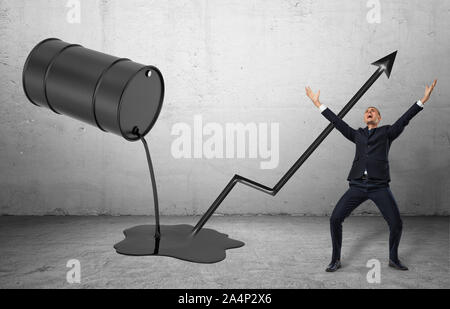 Schräge Fass mit schwarze Flüssigkeit gießen und glücklich Geschäftsmann in einem Feiern darstellen Stockfoto