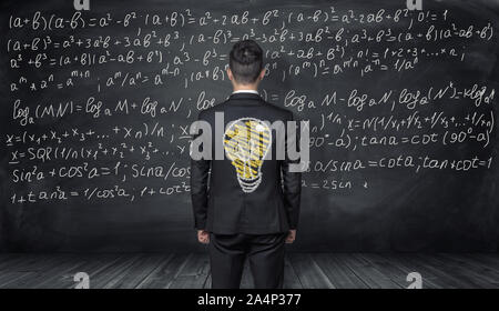 Unternehmer stehen mit der Zeichnung der Glühbirne auf dem Rücken Stockfoto