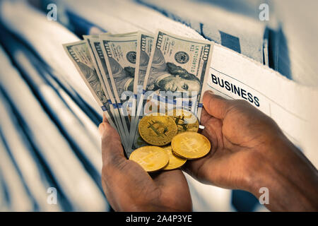 Afrikanische Frau Hände halten ein von Bitcoins und Dollar Stack, Stockfoto