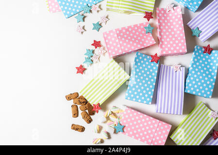 Zu Weihnachten Adventskalender mit mehrfarbigen Geschenkbeutel, Zahlen, und Süßigkeiten auf weißem Hintergrund. Oben Ansicht von gifting Zeit. Weihnachten Überraschungen. Stockfoto