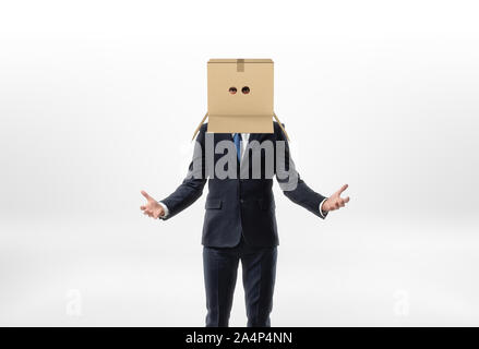 Unternehmer ist, seine Hände zu den Seiten mit einem Kasten auf seinem Kopf mit Löchern für die Augen auf weißem Hintergrund Stockfoto