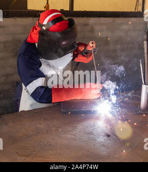 Motswana Schweißgerät Arbeiter in einer Botswana Workshop, Schweißen zwei Teile aus Metall Stockfoto