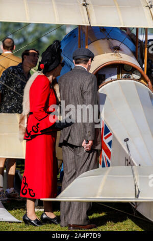 Smarly gekleidetes Ehepaar in Periode Kleidung an einem historischen Flugzeuge im Jahr 2019 Goodwood Revival, Sussex, UK. Stockfoto