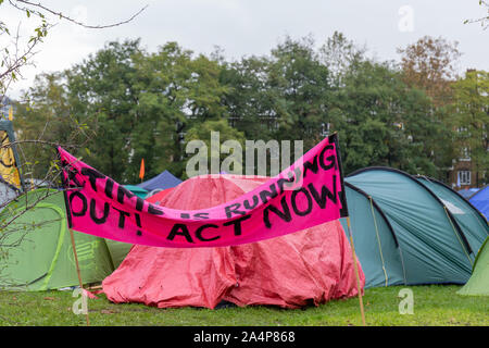 Vauxhall Pleasure Gardens, London, UK, 15. Oktober 2019; Camp Einrichten vom Aussterben Rebellion Gruppe mit bunten Zelte und Rosa Banner Stockfoto