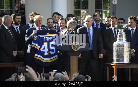 Washington, United States. 15 Okt, 2019. Präsident Donald Trump hält ein Hockey einheitliche präsentiert von St. Louis Blues National Hockey League Haupteigentümer Tom Stillman, als Cheftrainer Craig Berube, im Rosengarten des Weißen Hauses, Dienstag, Oktober 15, 2019, in Washington, DC sieht. Die Blues gewannen ihren ersten Stanley Cup (R) der letzten Saison. Foto von Mike Theiler/UPI Quelle: UPI/Alamy leben Nachrichten Stockfoto