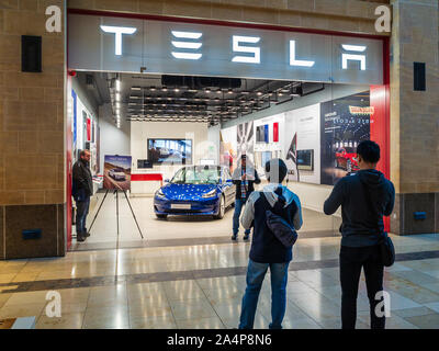 Tesla Showroom - Touristen machen Fotos vor dem Tesla Model 3-Auto in einem Tesla Dealership in Cambridge Stockfoto