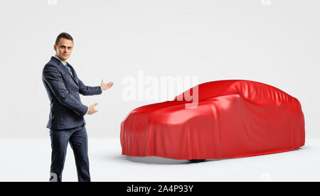 Ein Geschäftsmann mit einem Auto silhouette eingewickelt in ein rotes Tuch hinter ihm. Stockfoto