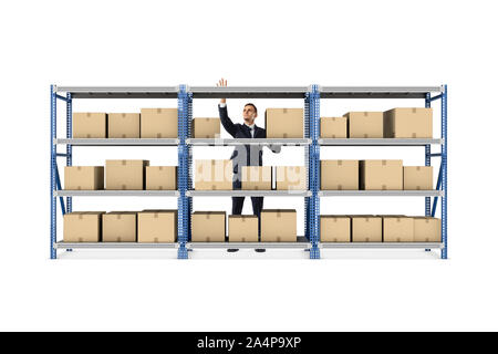 Ein Geschäftsmann hinter einem Metall warehouse Rack voller Kisten auf weißem Hintergrund stehen. Stockfoto