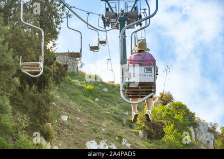 ANACAPRI, Capri, Italien - AUGUST 2019: Person auf einem Sessellift fahren den Berg hinauf auf den Gipfel des Monte Solaro oben Anacapri und nach unten Stockfoto