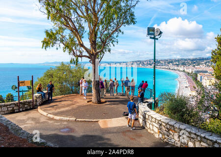 Eine Gruppe von Touristen und ein strassenmusiker versammeln sich auf einem Aussichtspunkt auf Castle Hill mit Blick auf Nizza Frankreich, die Bucht der Engel und der Französischen Riviera Beach Stockfoto