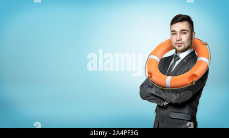 Ein Geschäftsmann in einer Vorderansicht mit Hände gekreuzt und eine orange Leben Boje hing an seinem Hals. Stockfoto