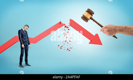 Eine kleine traurige Geschäftsmann steht in der Nähe ein rotes Statistik Pfeil, der von einer riesigen Hand mit einem Richter Hammer gebrochen. Stockfoto