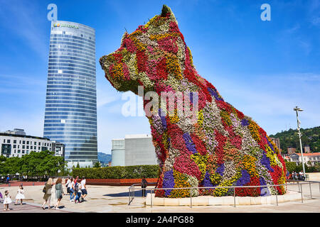 Seitenansicht von Jeff Koons Puppy, der riesigen blumenbewachsenen Terrier-Skulptur, neben dem Iberdrola-Turm beim Guggenheim-Museum Bilbao, Spanien Stockfoto