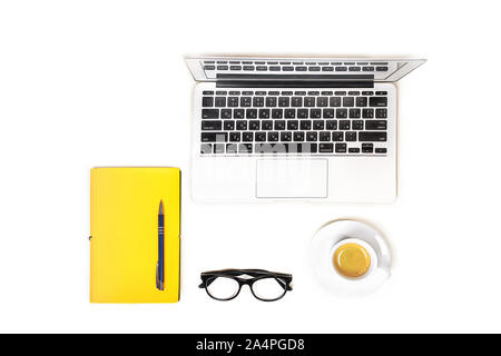 Arbeitsbereich mit Laptop Notebook, Mode Gläser, Tasse Kaffee, gelbe Notizbuch mit Stift auf weißem Hintergrund, isoliert. Ansicht von oben. Flach. Konzept online einkaufen. Stockfoto