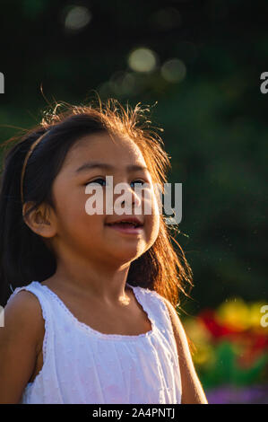 Süße Mexikanische amerikanische Kinder spielen und genießen Blasen in einem Garten Park. Latino Jugend gemeinsam Spaß zu haben. Stockfoto