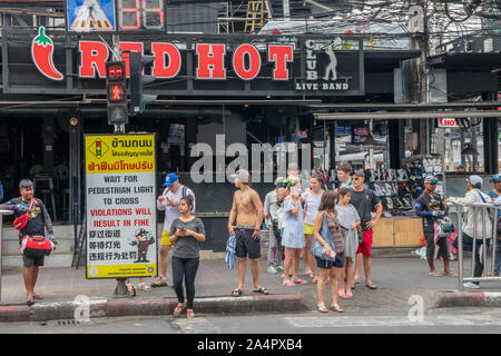 Patong, Phuket, Thailand - 17. Januar 2019: Touristen warten, die Straße an einem fußgängerüberweg zu überqueren. Polizei feine Übertreter. Stockfoto