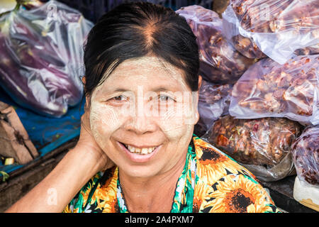 Mae Sot, Thailand - 3. Februar 2019: Porträt eines lächelnden Frau Anbieter am Markt. Thanaka Paste ist als kosmetisches verwendet. Stockfoto