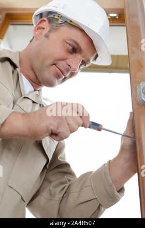 Schloss-Hausservice - Schlosser Arbeiten in roten uniform Stockfoto