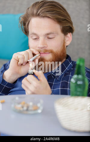 Junger Mann zu Hause Beleuchtung eine gemeinsame Stockfoto