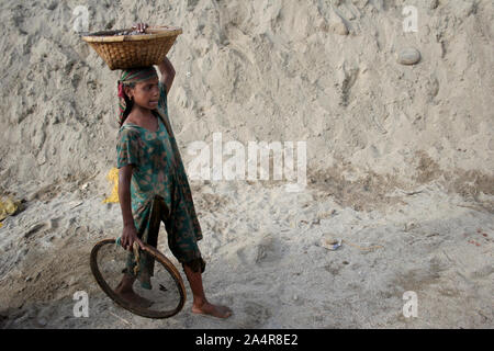 Ein junges Mädchen trägt Steine und Kiesel aus einem Steinbruch gesammelt, am Ufer des Flusses Dauki, Sylhet, Bangladesh. 18. Januar 2010. Stockfoto