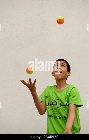 Ein Kind Jongleur am Mobile Mini Circus für Kinder (MMCC), in Herat, Afghanistan. Mai 9, 2009. Das Zentrum bietet Ausbildung auf aerobe Übung und darstellende Kunst neben psychologische Unterstützung und Hilfe mit den Realitäten des Krieges in Verbindung stehende Gewalt, die Teil des Lebens für alle afghanischen Kinder geworden sind. Stockfoto