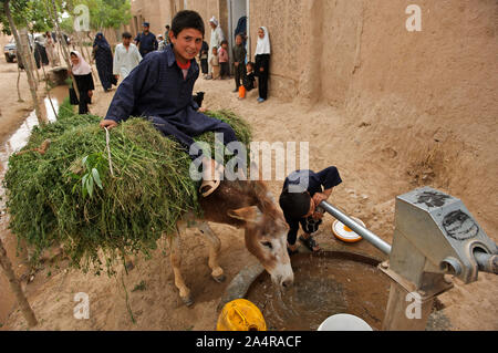 Ein Junge Getränke Wasser aus einer Hand Pumpe, im Ortsteil Zindajan, Afghanistan. 7. Mai 2009. Stockfoto