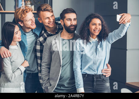 Startupers zusammen arbeiten im Büro ständigen Umarmen unter selfie Fotos glücklich Stockfoto