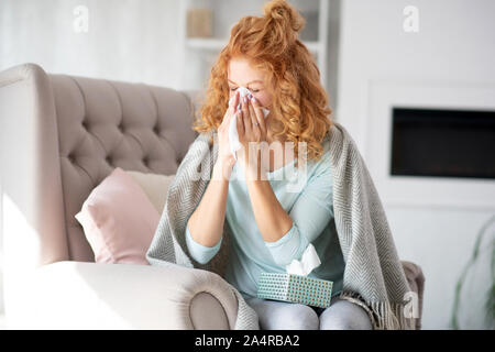 Curly Frau mit Plaid auf Schultern in laufende Nase Stockfoto