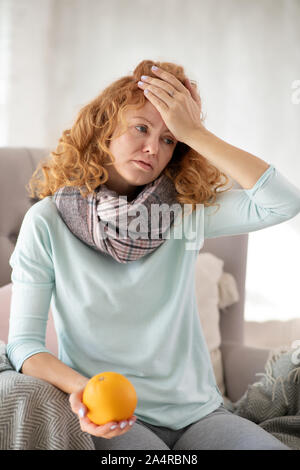 Curly Frau orange halten und müssen Vitamin C Grippe in Stockfoto