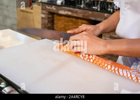 Chef vorbereiten und schneiden frischer Lachs im Japanischen Restaurant Stockfoto