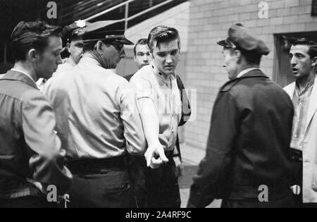 Elvis Presley spricht mit Polizisten an der Universität von Dayton Fieldhouse, 27. Mai 1956. Stockfoto